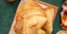 three pastries sitting on top of a wooden cutting board