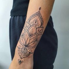 a woman's arm with a tattoo design on the left side of her arm