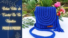 a blue crocheted bag sitting on top of a table next to a plant