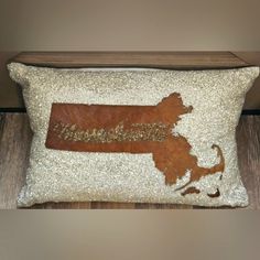 a decorative pillow with the state of rhode painted on it in gold glitters and sequins