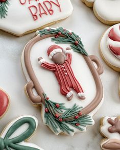 decorated cookies are arranged on a table for baby's first christmas cookie decorating