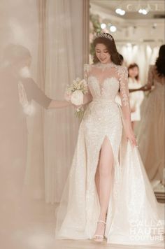 a woman in a wedding dress is walking down the aisle with her hand on her hip