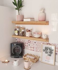 a kitchen counter with coffee maker, mugs and other items on it