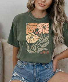 Looking for a comfortable and stylish t-shirt that shows off your love for flowers and nature? Our floral t-shirt with a beautiful wildflowers aesthetic print is the perfect choice! Featuring a stunning print of wildflowers in a gorgeous, natural setting, this t-shirt is perfect for anyone who loves spending time outdoors and appreciates the beauty of nature. The colors are vibrant and eye-catching, and the print is sure to attract compliments wherever you go. Made from high-quality materials, t Green Casual T-shirt For Spring, Spring Shirt With Front Print In Relaxed Fit, Spring Shirt With Front Print And Relaxed Fit, Green Letter Print Top For Spring, Spring Green Top With Letter Print, Spring Shirt With Front Print And Crew Neck, Spring Crew Neck Shirt With Front Print, Green Floral Print Tops With Relaxed Fit, Green Floral Print Short Sleeve Top