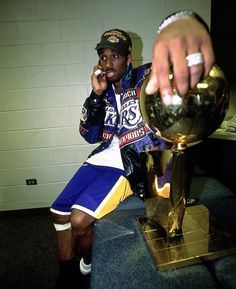 a man sitting on top of a table next to a trophy