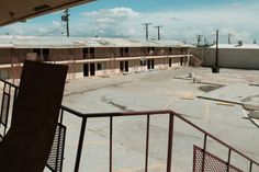 an empty parking lot with several motels in the background