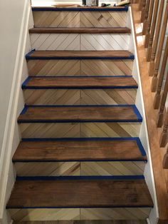 some stairs with blue tape on them and wood flooring in the bottom part of it