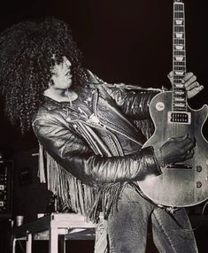 a man with an afro holding a guitar