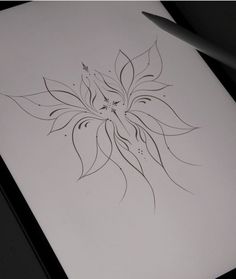 a drawing of a flower is shown on a piece of paper with a pen next to it