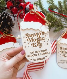 a person holding up a christmas ornament with santa's magic key on it