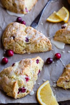 cranberry orange scones on parchment paper with lemon wedges next to them