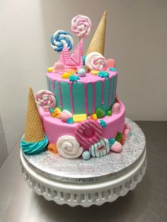 a pink and blue cake with candy on top