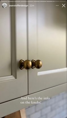 a white cabinet with two brass knobs and a quote on the door that says, and there's the info on the knobs