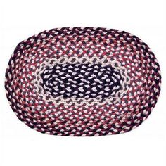 a red, white and black braided rug with an oval design on the center