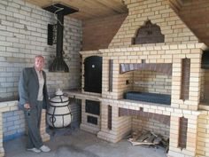 a man standing in front of a fake house made out of bricks and wood blocks