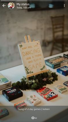 a sign that is sitting on top of a table with some books and video game controllers