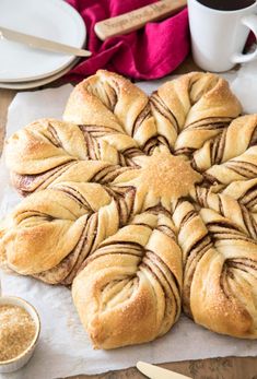 a pastry with chocolate swirls on it sitting next to a cup of coffee and utensils