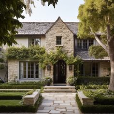 a house with stone steps leading up to the front door and trees in front of it