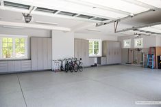 an empty garage with several bikes parked on the floor and storage cabinets in the back