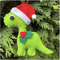 a green dinosaur ornament with a santa hat on