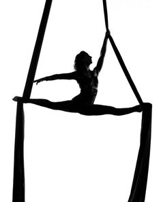 a woman is doing aerial acrobatic tricks on a pole in the air