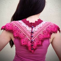 the back of a woman's pink top with crocheted details