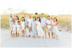 a family poses for a photo on the beach in front of tall grass and sand dunes