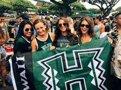 a group of women holding up a large green banner