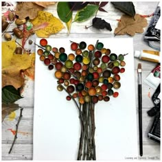 a tree made out of marbles sitting on top of a piece of paper