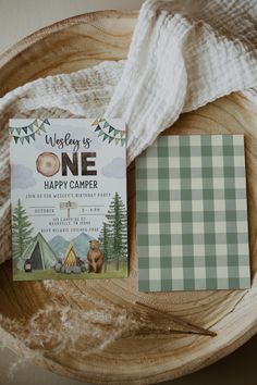 a wooden bowl with a note card on top of it next to a plaid blanket