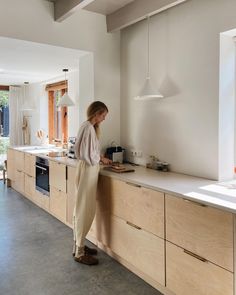 a woman standing at the counter in a kitchen