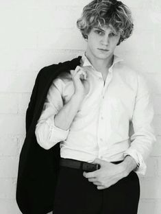 black and white photograph of a young man with curly hair wearing a shirt and pants