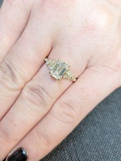 a woman's hand with a ring on top of it and a diamond in the middle