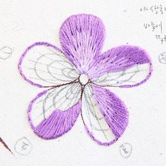 a close up of a purple flower on a piece of paper with writing underneath it