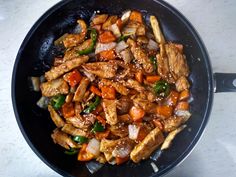 chicken and vegetables cooking in a wok on the stove