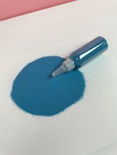 a blue ink pen sitting on top of a piece of paper with sprinkles