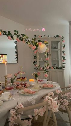 a dining room table with flowers and candles on the table for an elegant tea party