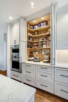 a large kitchen with white cabinets and marble counter tops