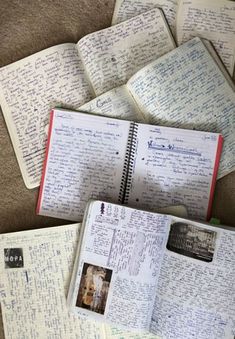 several notebooks with handwritten notes on them sitting on the floor next to each other