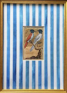 two birds sitting on top of a blue and white striped wall next to a gold frame