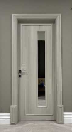 an empty room with a white door and mirror