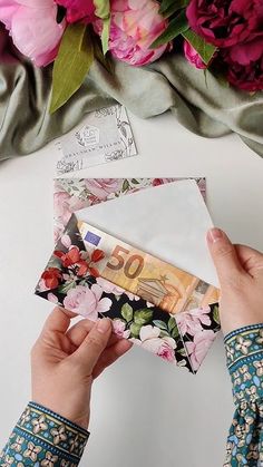 a person is opening an envelope with flowers on it