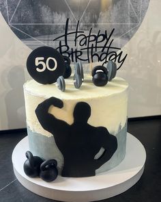 a birthday cake decorated with an image of a man and dumbbells on top