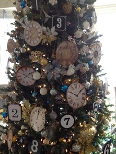 a decorated christmas tree with clocks on it's sides and numbers hanging from the top