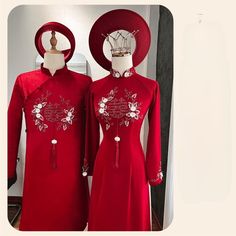 two mannequins dressed in red dresses and hats, one wearing a crown