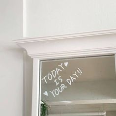 a mirror with the words today is your day written in white paint on it and a potted plant