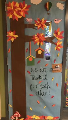 a door decorated with fall leaves and a tree that says, we are thanksgiving for each other