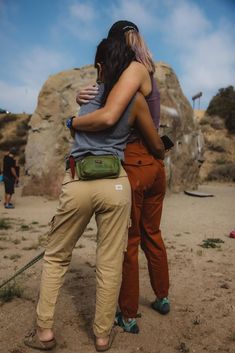 two women hugging each other in the desert