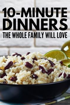 a black bowl filled with rice and beans next to lime wedges on a table