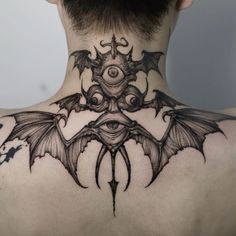 the back of a man's neck with an intricate tattoo design on his chest